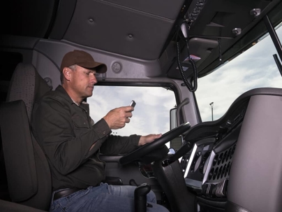 a trucker looking at his phone while driving